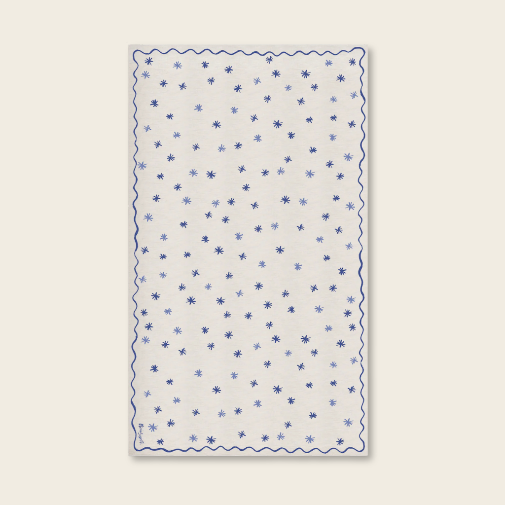 White fabric table cloth with blue star pattern on a beige background
