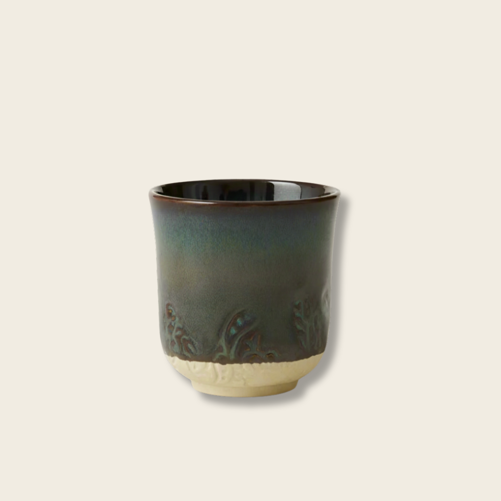 Ceramic cup with brown rim on a light beige background