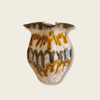 Ceramic vase with brown and beige patterns on a light beige background