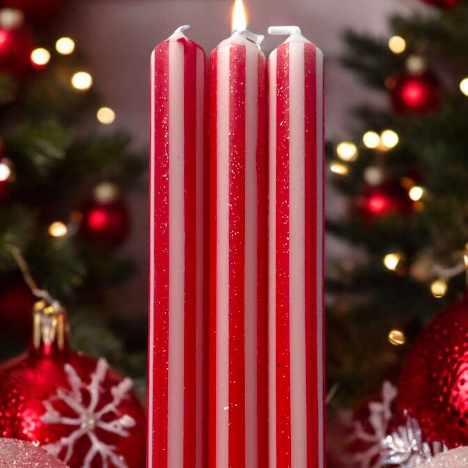 Red and white striped candles with Christmas decorations in the background