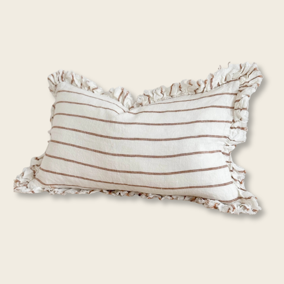 Striped pillow with ruffled edges on a beige background