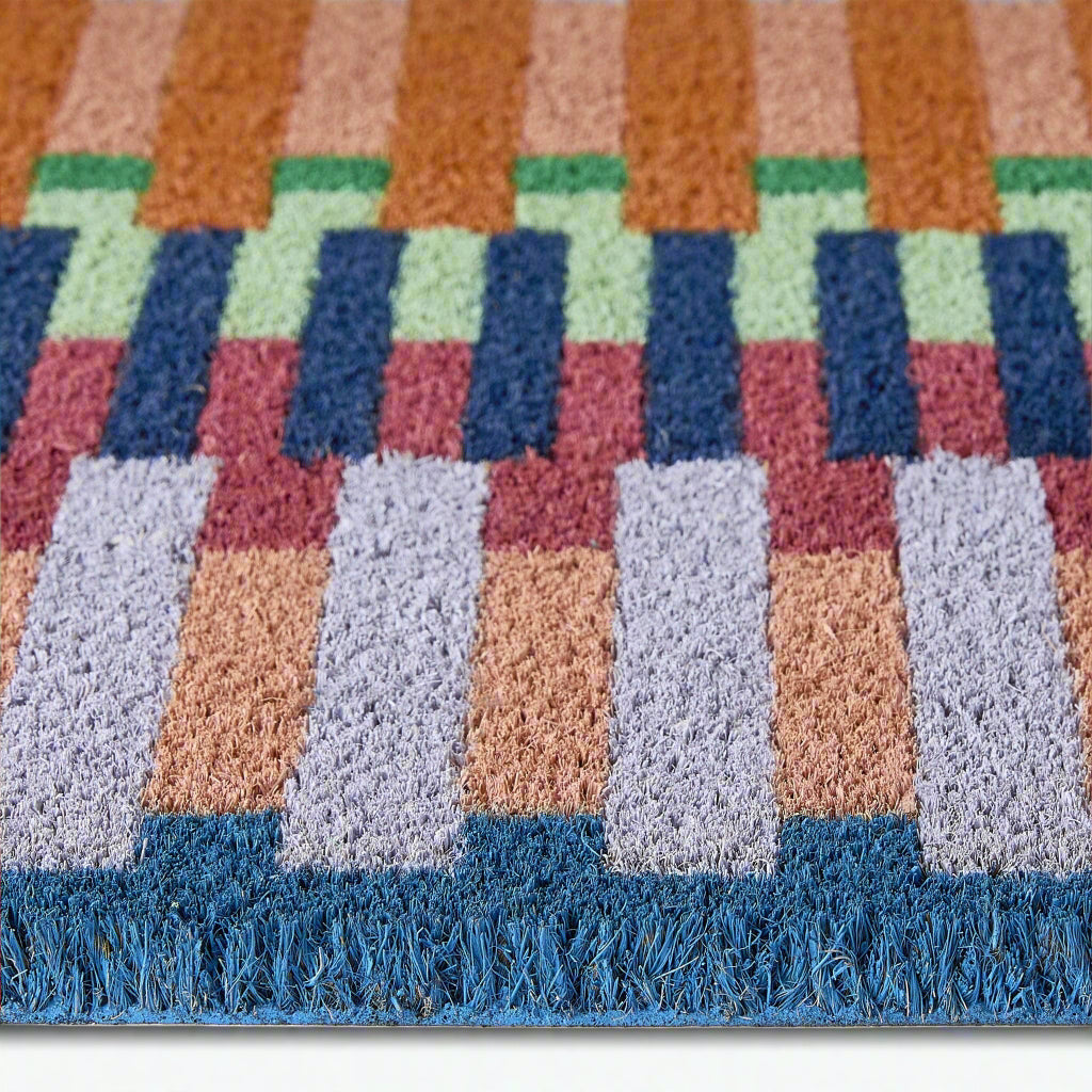 Close-up of a colorful checkered doormat with geometric pattern