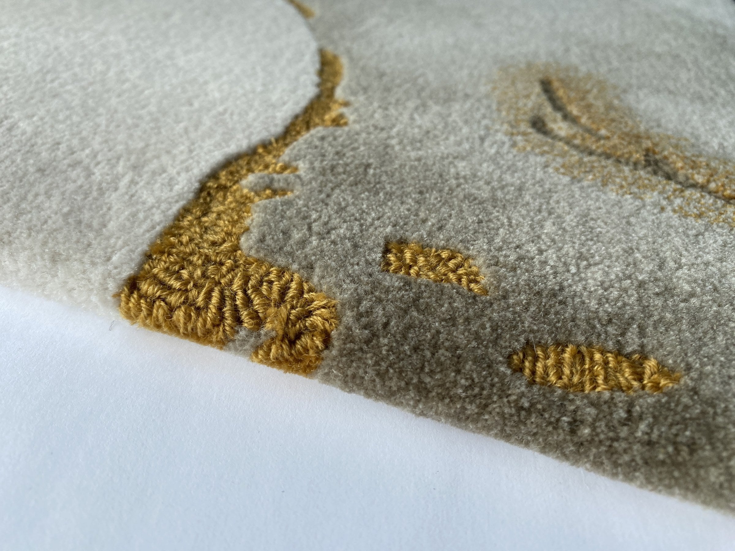 Close up of the Terra rug showing the cut and loop pile and gold veining