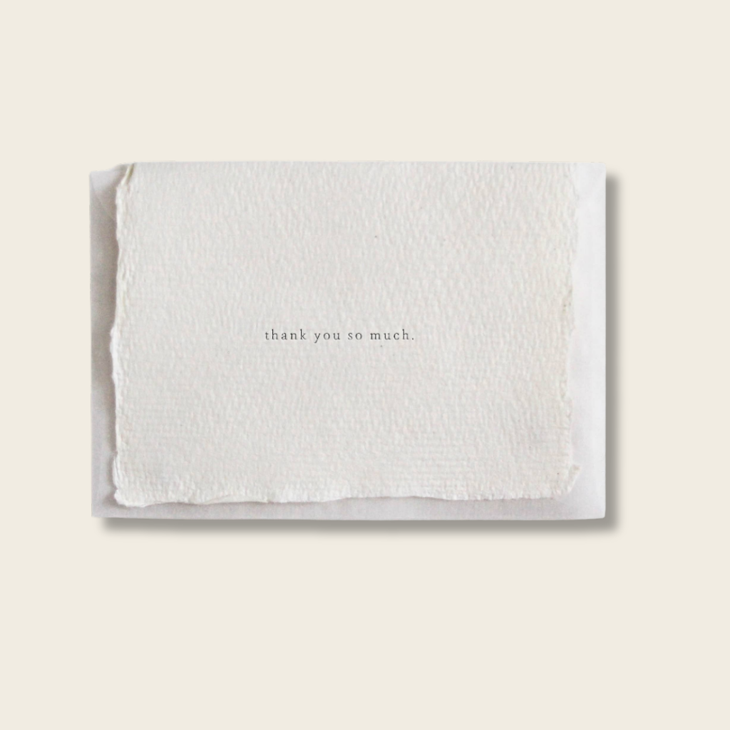 White textured card with 'thank you so much' text on a beige background