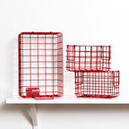 Two red wire baskets on a white shelf with a white background
