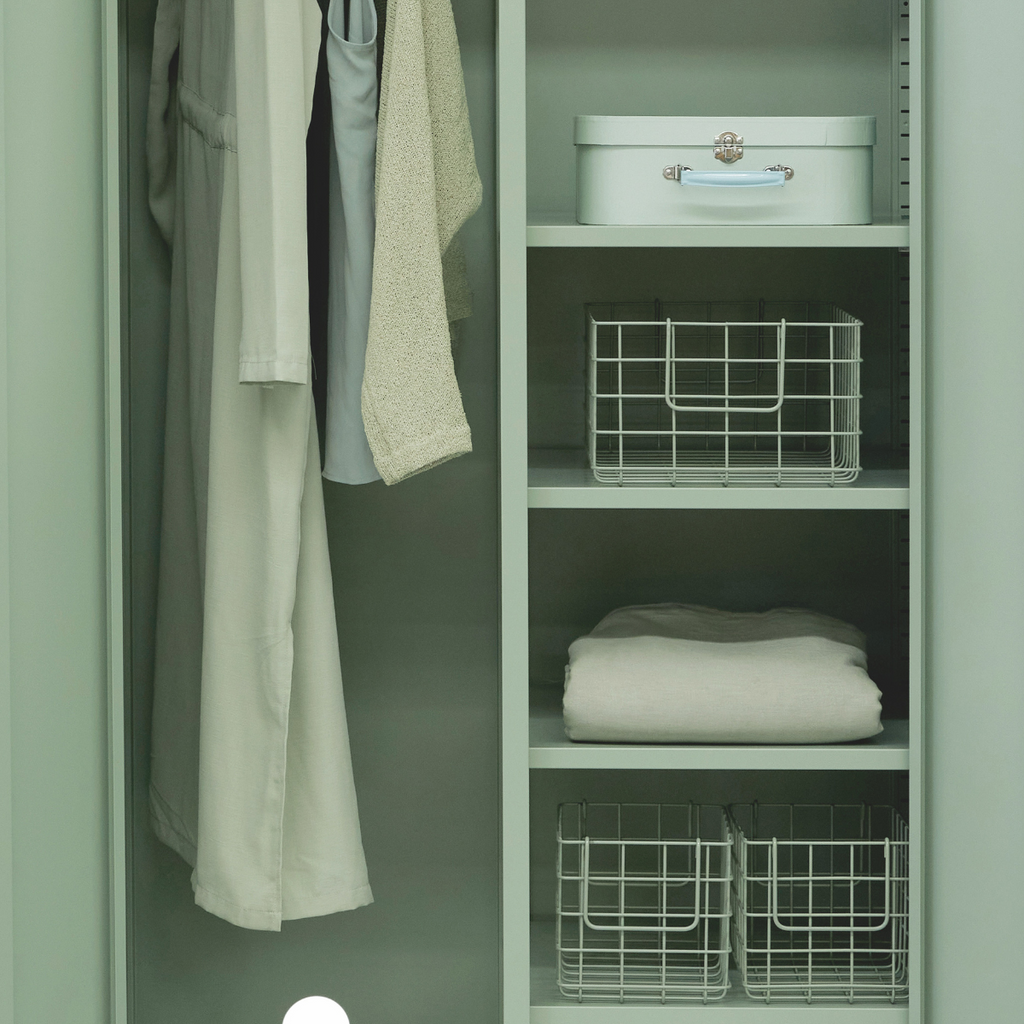 Green wardrobe with clothes and storage baskets