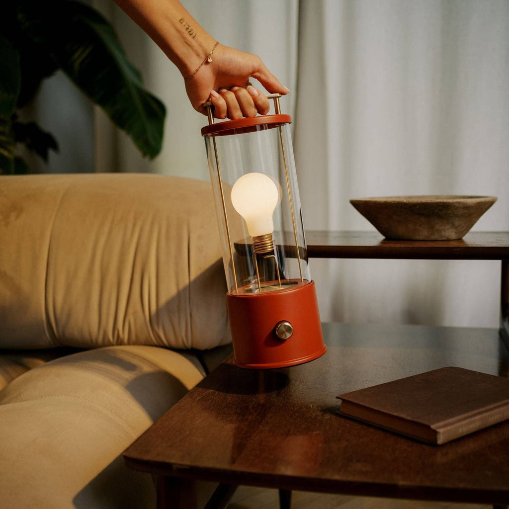 The Muse portable lamp in Pomona Red shown lit