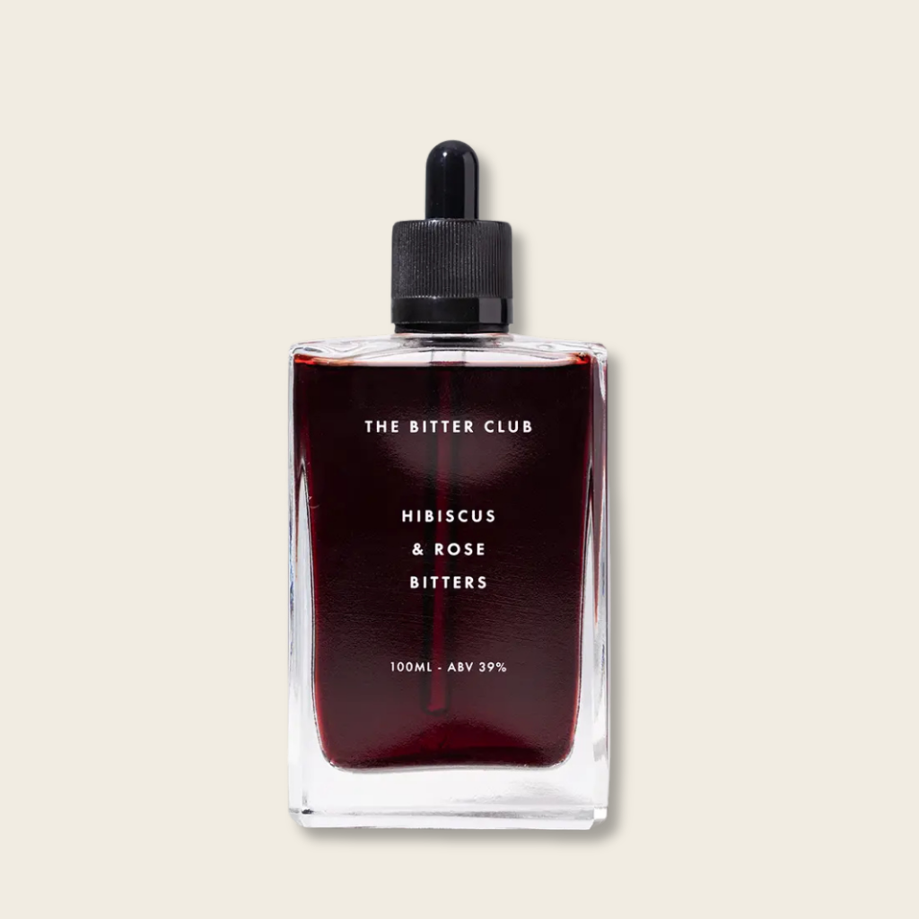 Bottle of The Bitter Club Hibiscus & Rose Bitters on a beige background