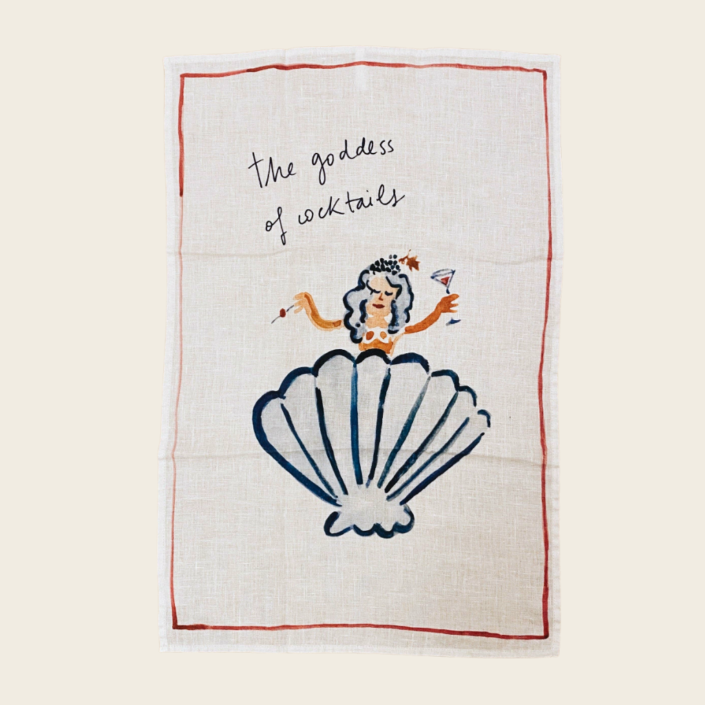 stonewashed linen teatowl with a lady coming out of a shell and text saying the goddess of cocktails