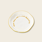 White plate with gold text on a beige background