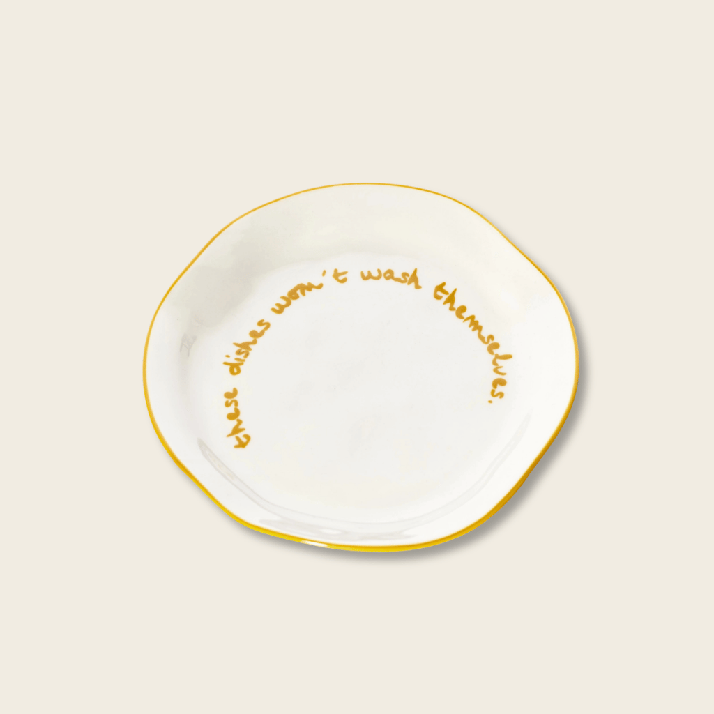White plate with gold text on a beige background