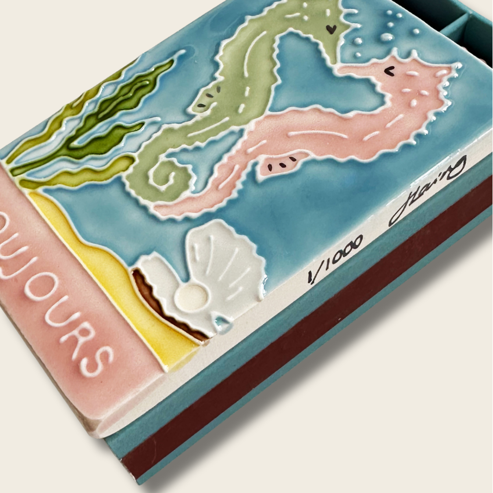 Decorative box with seahorse and shell design on a white background