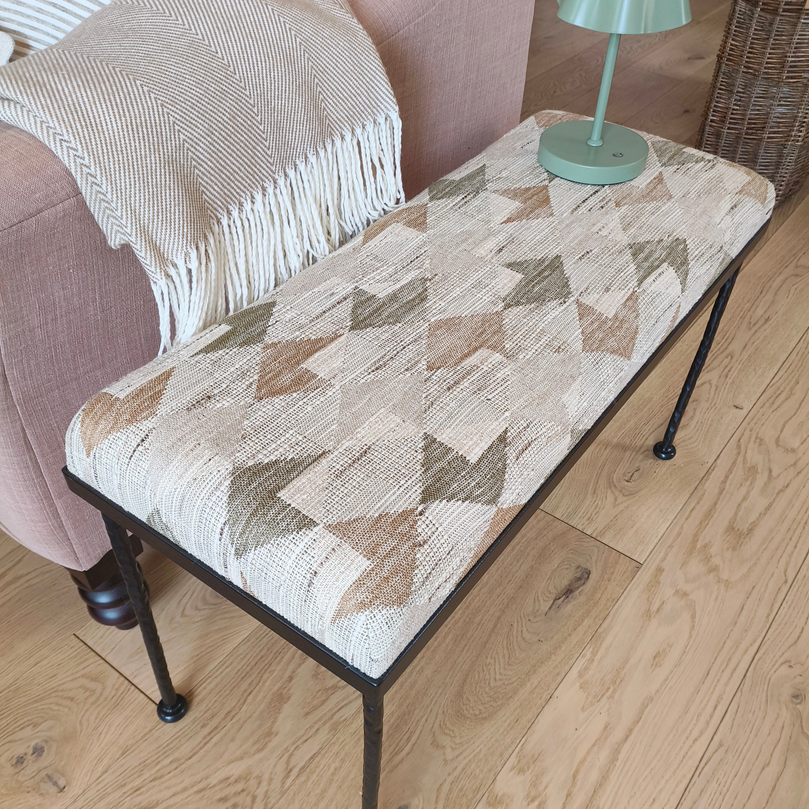 Small table with geometric patterned top next to a chair on a wooden floor