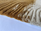 Close up of the Trove amber rug showing the cut pile and cream and gold tortoiseshell markings