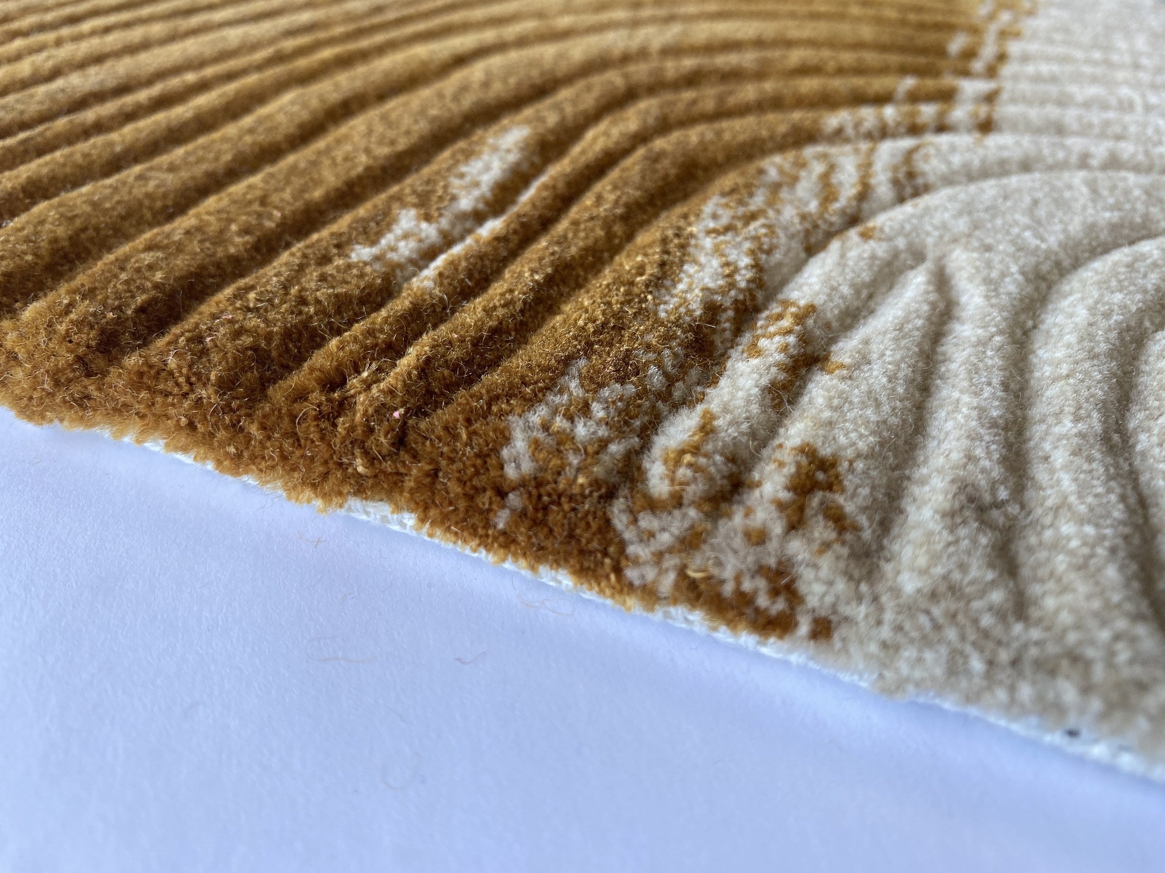 Close up of the Trove amber rug showing the cut pile and cream and gold tortoiseshell markings