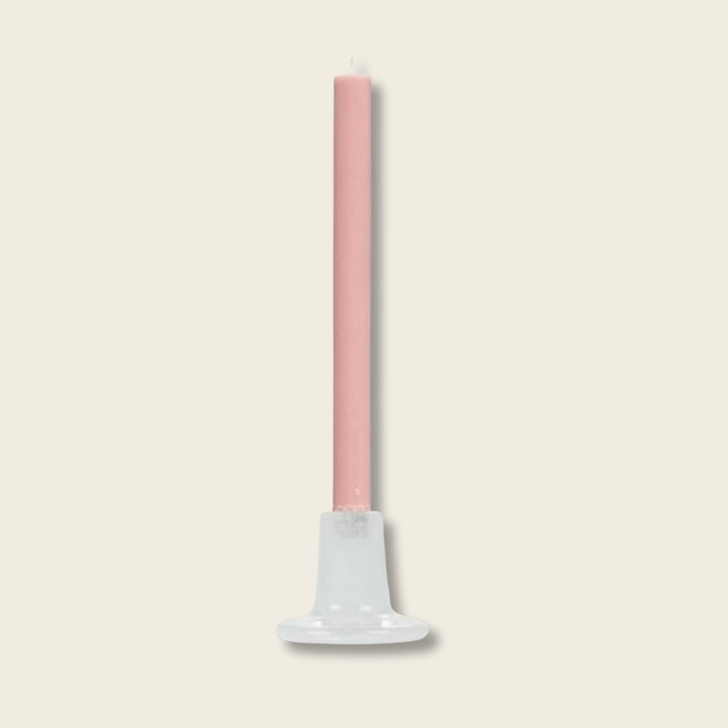 Pink candle on a white stand against a white background