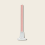 Pink candle on a white stand against a white background