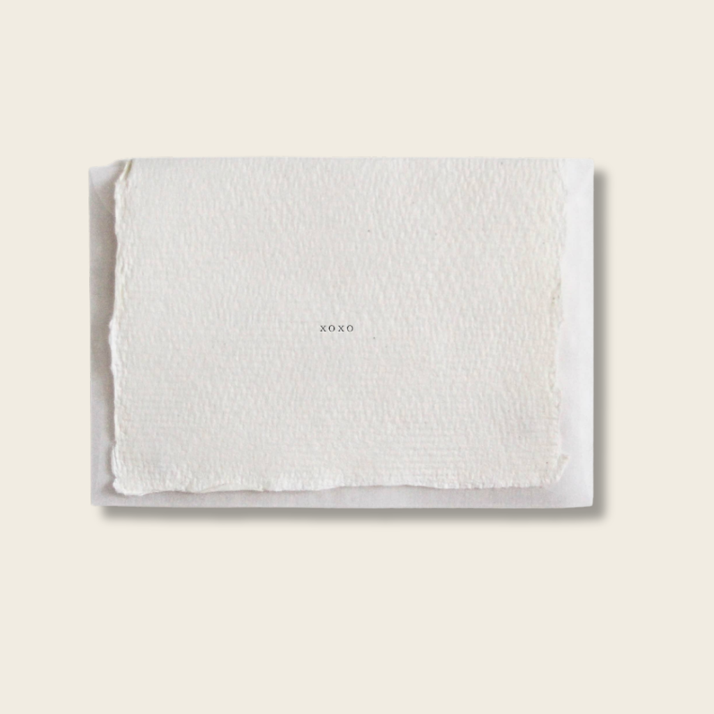 White textured towel with 'XOXO' embroidery on a light beige background